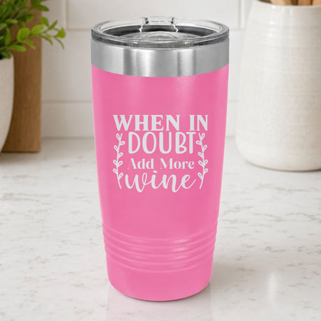 Pink 20 oz tumbler laser engraved with "When in Doubt, Add More Wine", on a kitchen counter