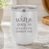 White 12 oz stemless wine tumbler laser engraved with "Wine Goes In, Wisdom Comes Out", on a kitchen counter