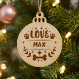 Round natural wood Christmas ornament engraved with the Love dog design and a sample pet name