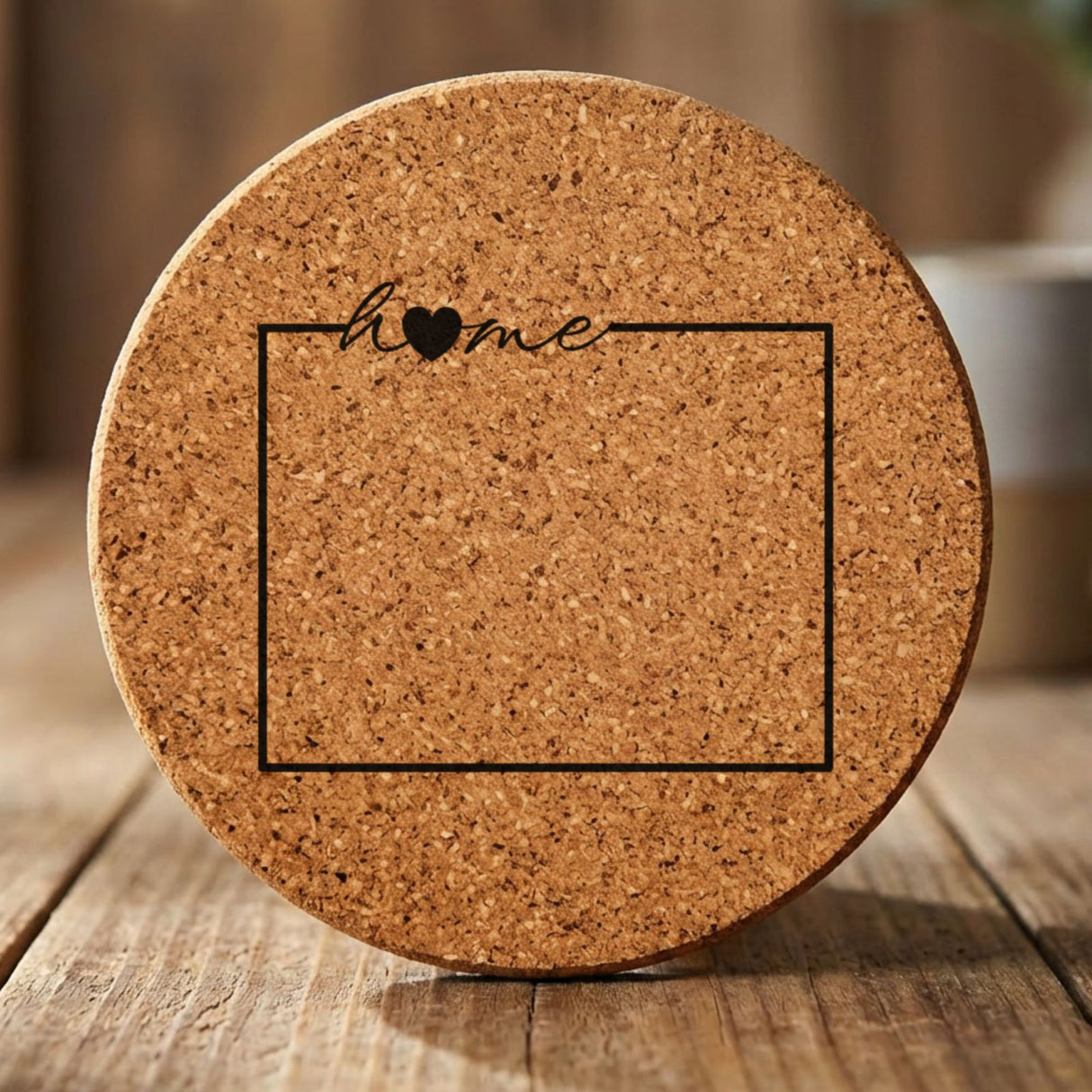 Wyoming round cork coaster engraved with the state outline and home in script with a heart