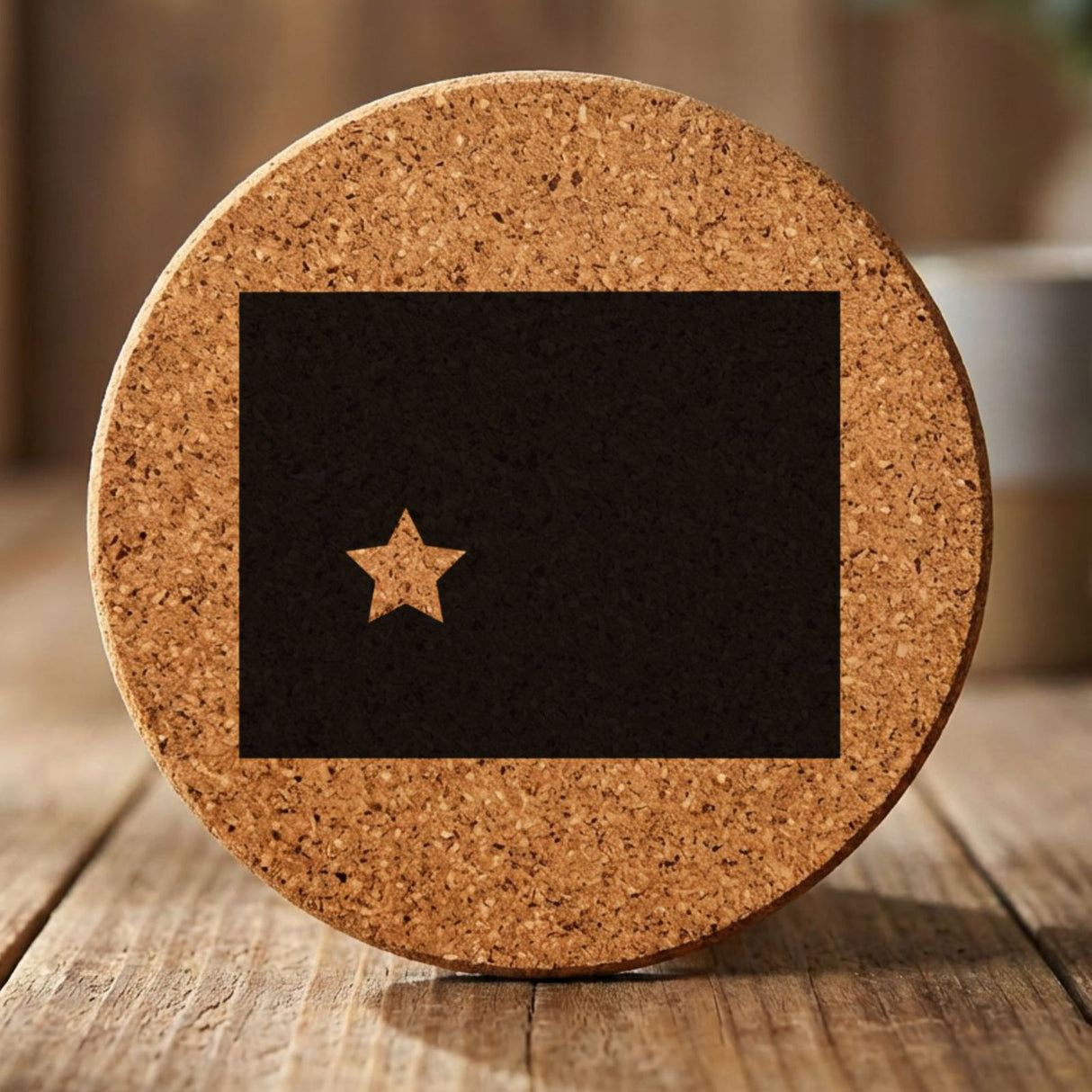 Wyoming round cork coaster engraved with the state shape and a star