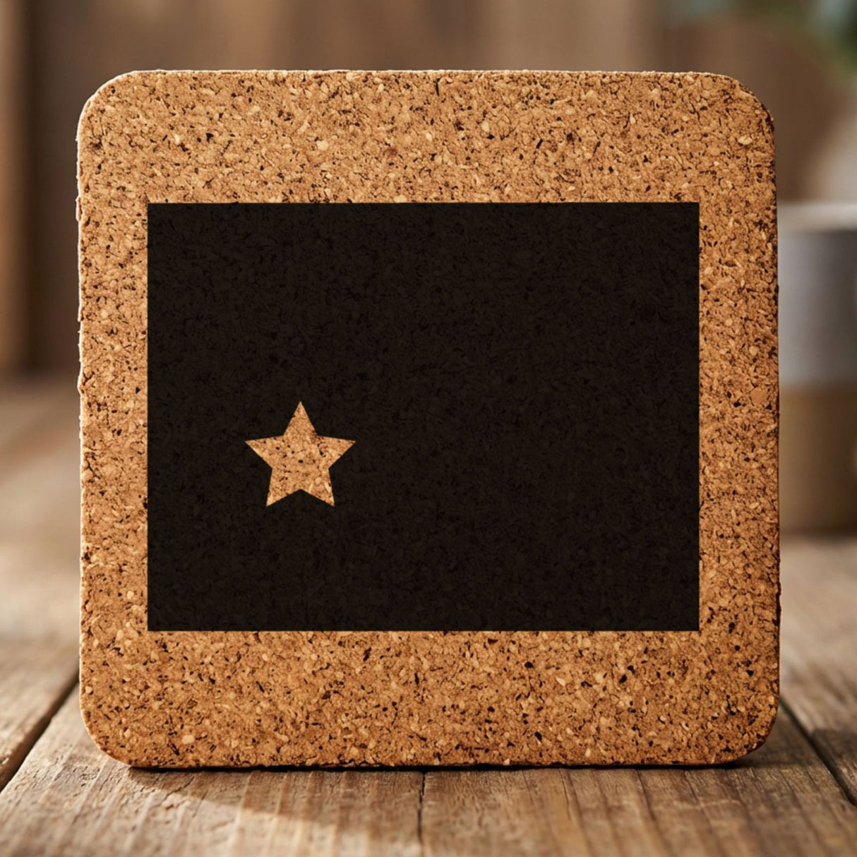 Wyoming square cork coaster engraved with the state shape and a star
