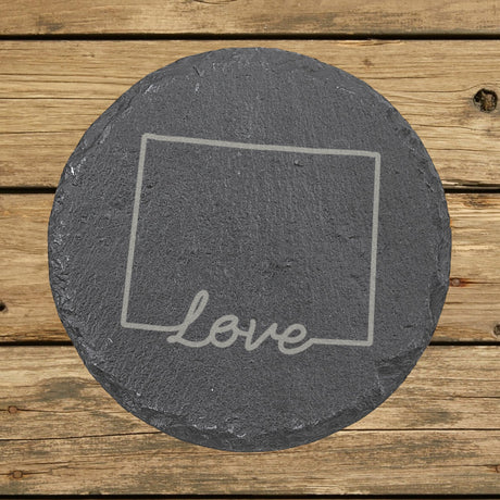 Wyoming round slate coaster engraved with a hand-drawn state outline and love in cursive