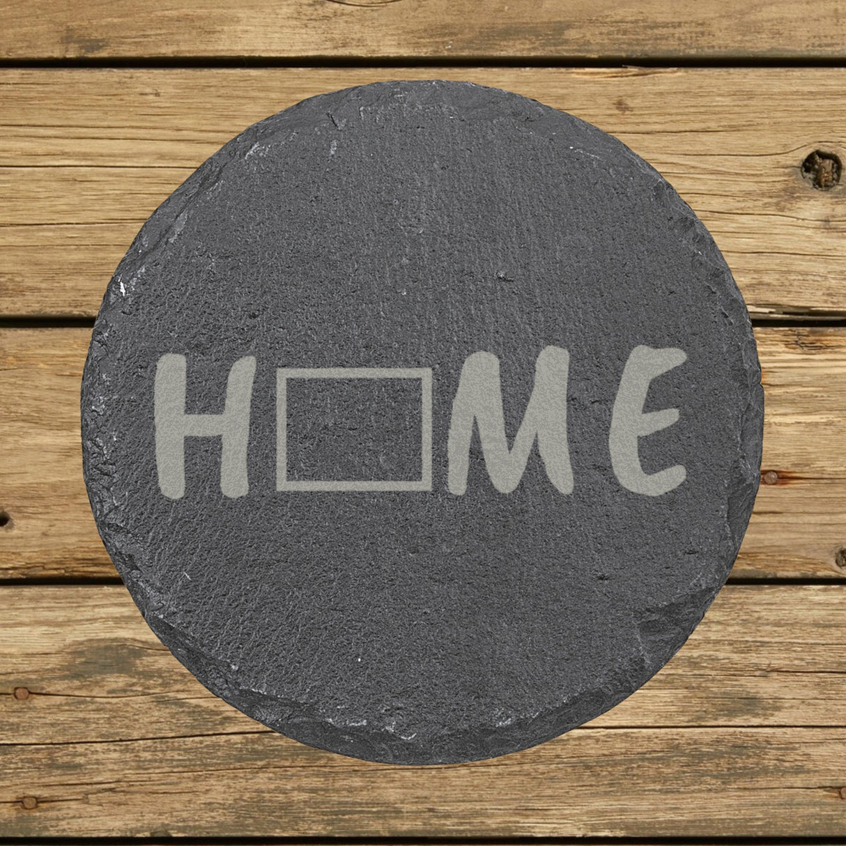 Wyoming round slate coaster engraved with HOME using the state outline as the letter O