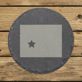 Wyoming round slate coaster engraved with the state shape and a star