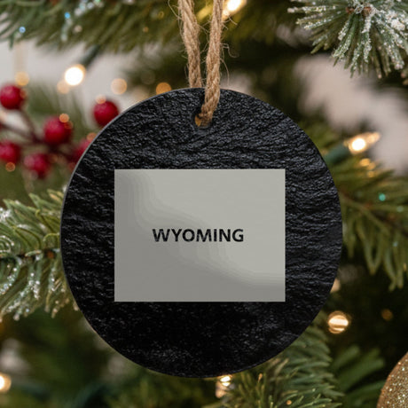Wyoming round slate Christmas ornament engraved with the state shape and WYOMING in bold lettering