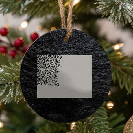 Wyoming round slate Christmas ornament engraved with the state shape in ornate floral scrollwork
