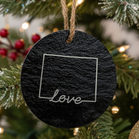 Wyoming round slate Christmas ornament engraved with a hand-drawn state outline and love in cursive