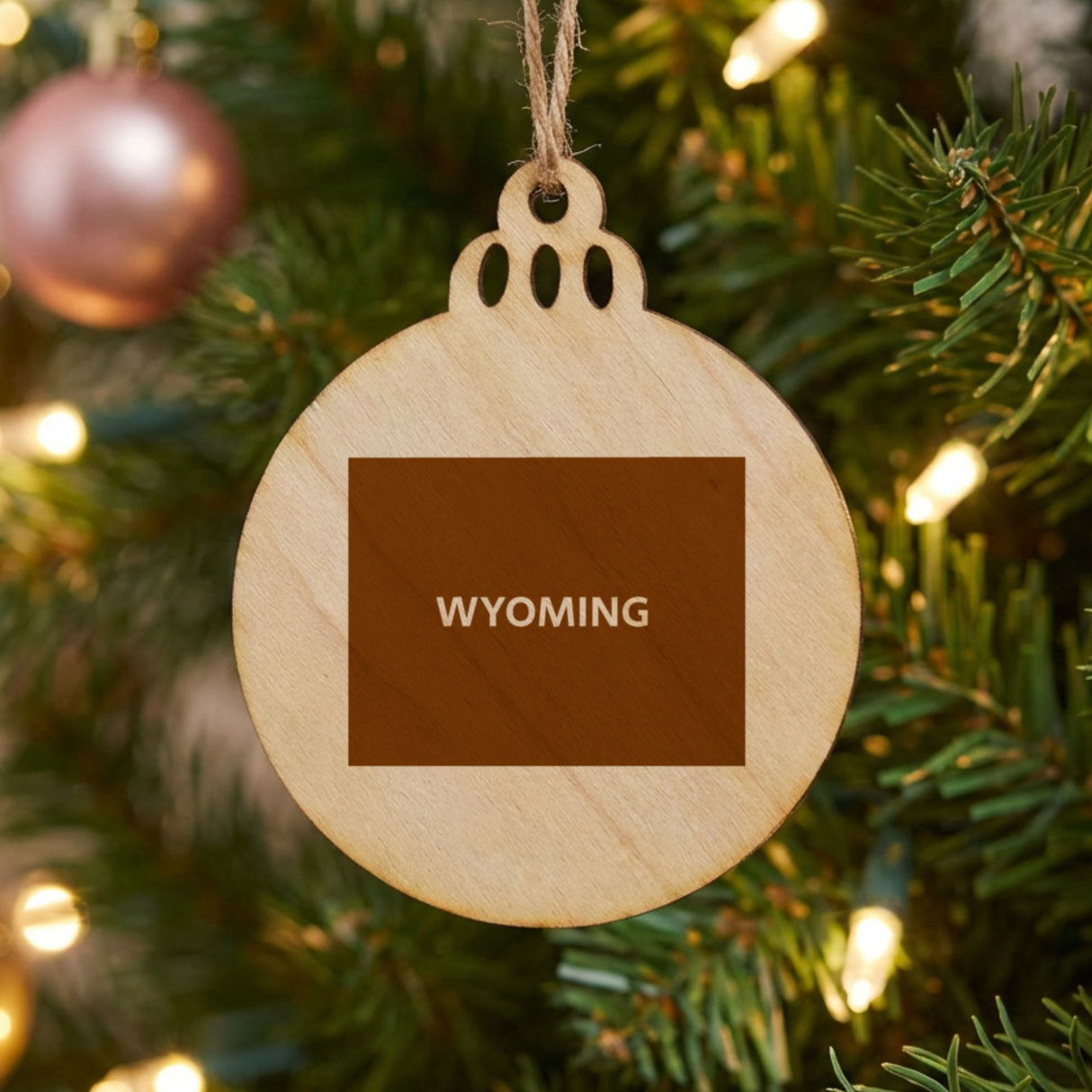 Wyoming round wood Christmas ornament engraved with the state shape and WYOMING in bold lettering
